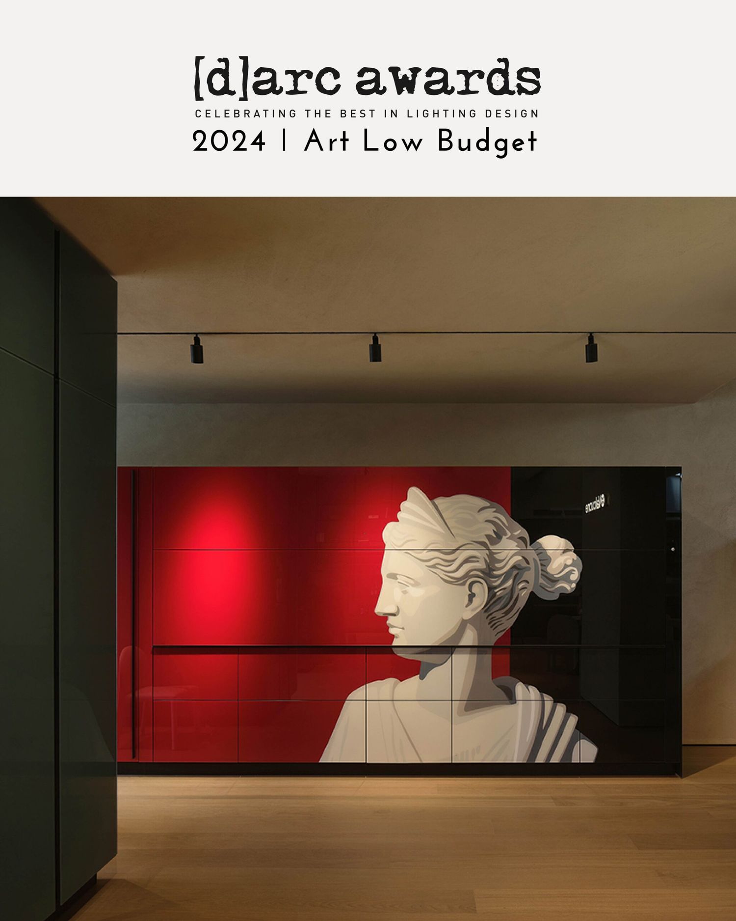 Classical white bust on a bold red wall in an art gallery with track lighting overhead