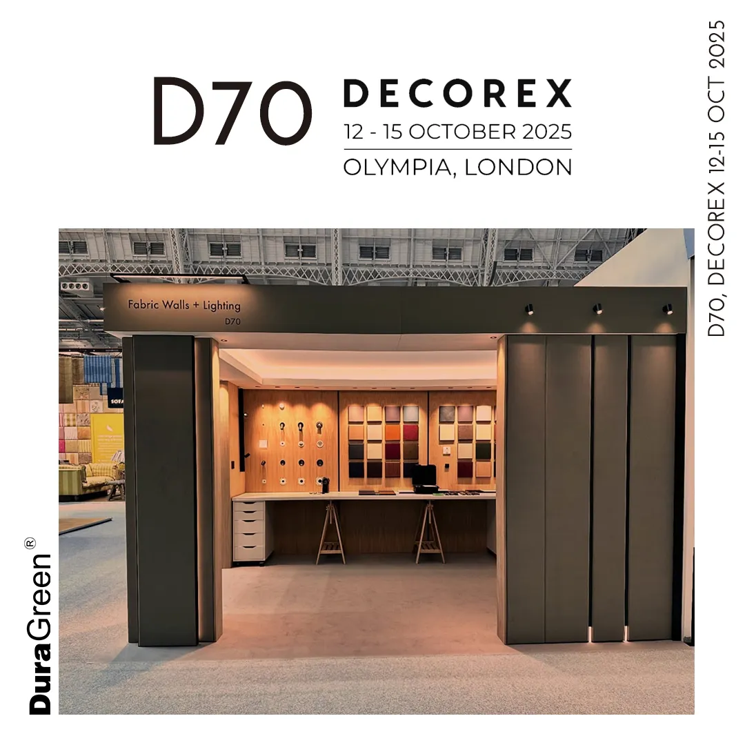 Exhibition booth labeled Fabric Walls + Lighting with wood sample wall and display panels at Decorex D70, 2025. DuraGreen branding visible.