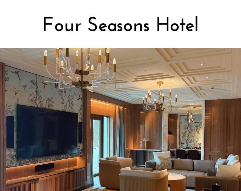 Lobby of the Four Seasons Hotel with crystal chandeliers, warm lighting and comfortable seating.