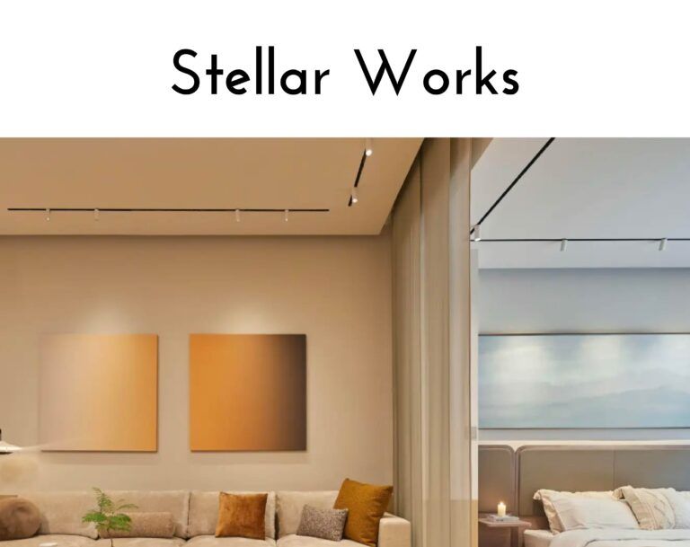 Contemporary showroom living room: beige walls, orange wall panels, and a beige sofa with multiple cushions across the room.