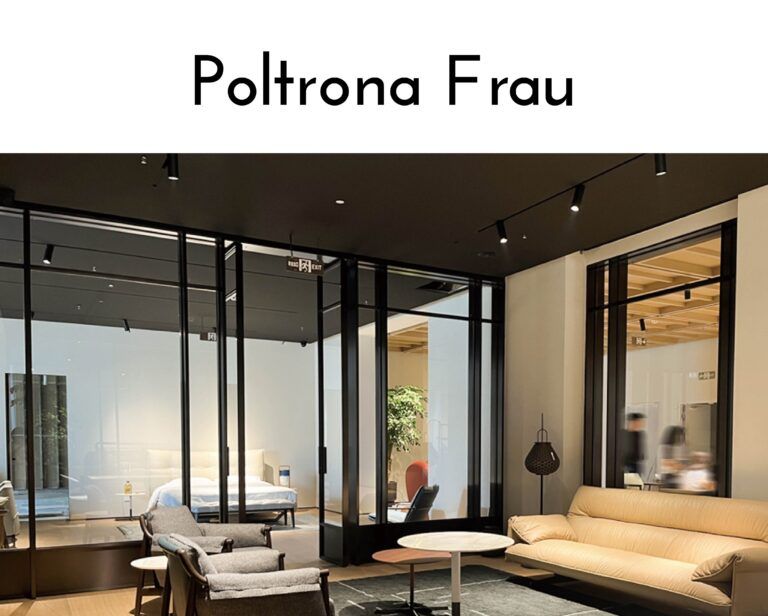 Showroom interior with glass walls displaying modern living room furniture and a large Poltrona Frau sign above.