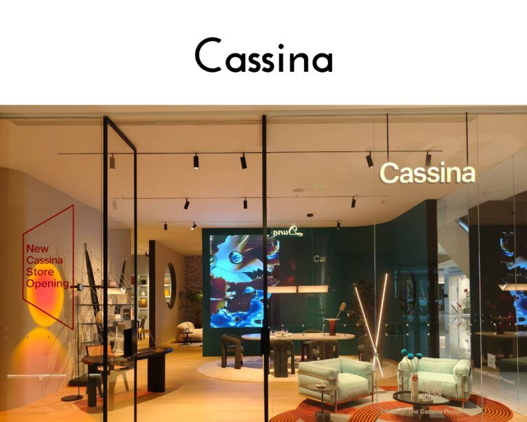 Inside a Cassina showroom: modern furniture on display behind glass, with the Cassina logo visible at the top right.