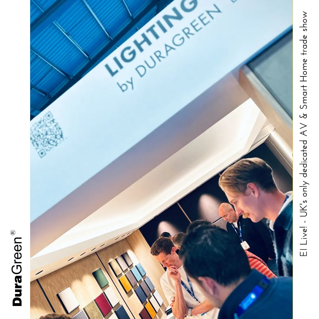 Trade show booth for Lighting by DuraGreen with attendees discussing lighting samples and a wall of color swatches behind them.