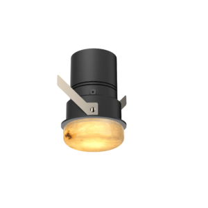 Close-up of a black stage spotlight with beige mounting brackets and a warm amber-lit lens.